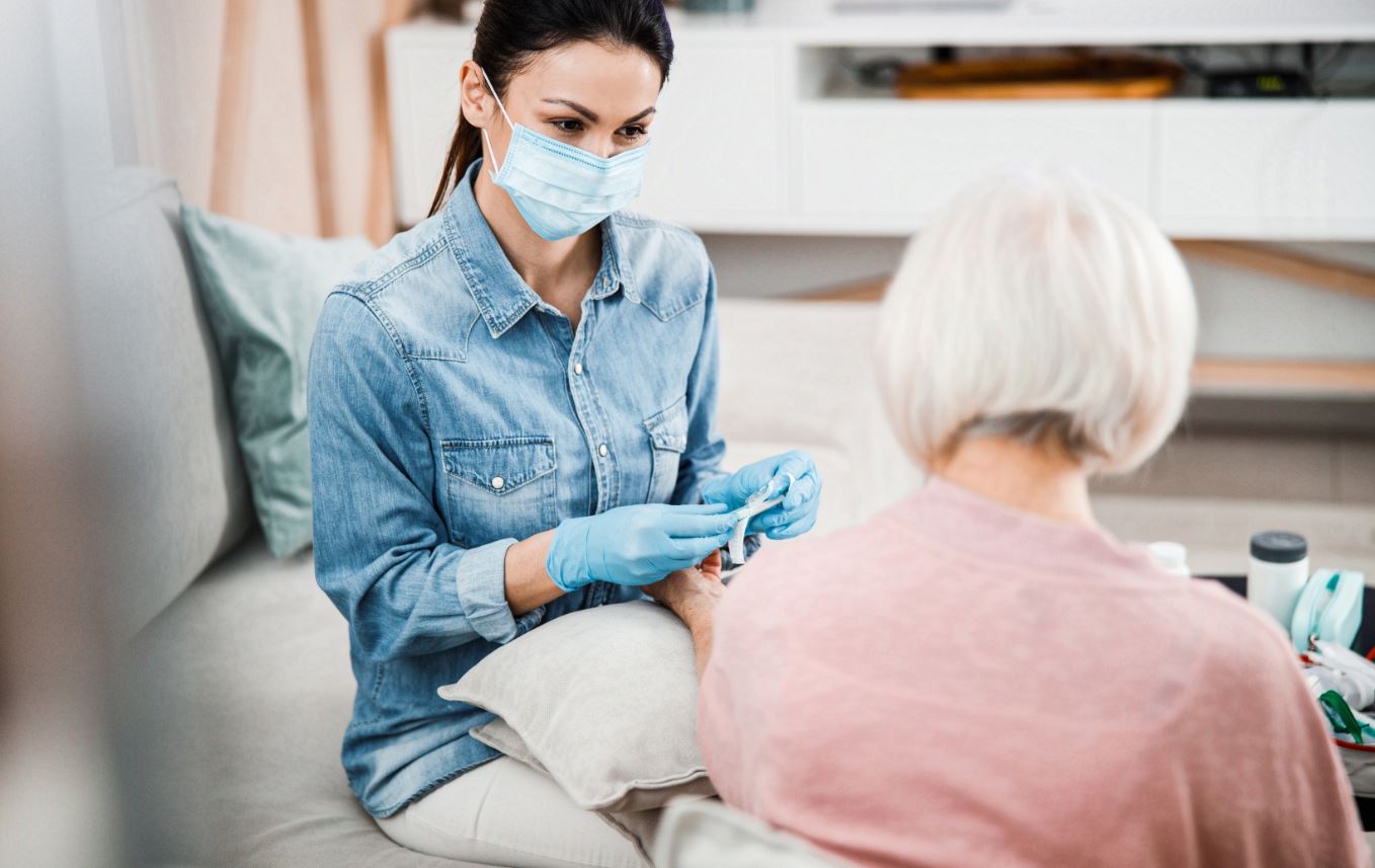 Frau mit Maske im Pflegeheim bei der Arbeit